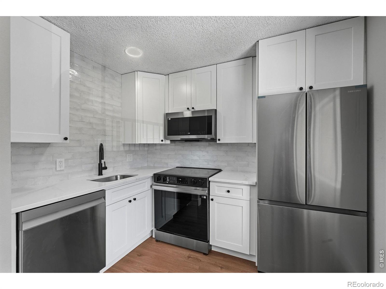Image 2: 2026 custom kitchen with premium quartz counters, soft close Shaker cabinets, Samsung appliance package with ice maker, and plank flooring Image 2: 2026 custom kitchen with premium quartz counters, soft close Shaker cabinets, Samsung appliance package with ice maker, and plank flooring