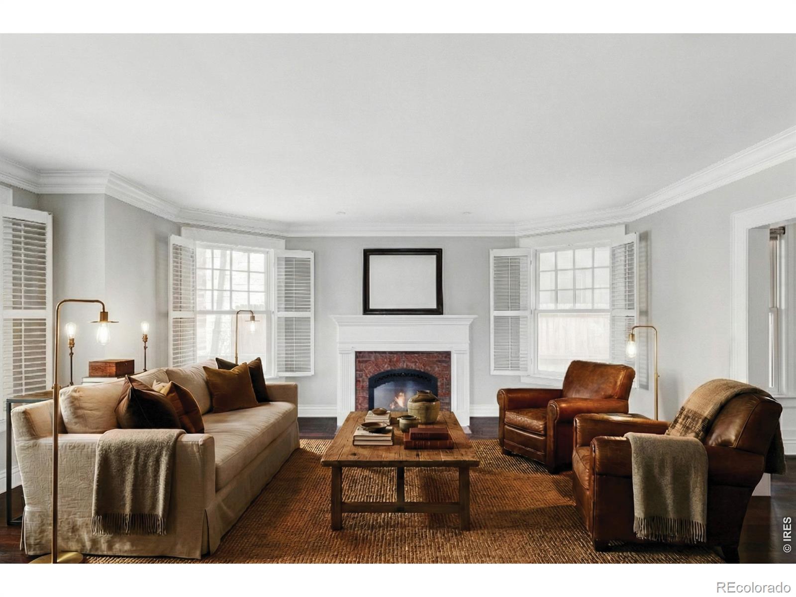 Image 2: The front living room centers on a gas fireplace flanked by shuttered windows, a warm and inviting setting for evenings in. (Photo is virtually staged) Image 2: The front living room centers on a gas fireplace flanked by shuttered windows, a warm and inviting setting for evenings in. (Photo is virtually staged)