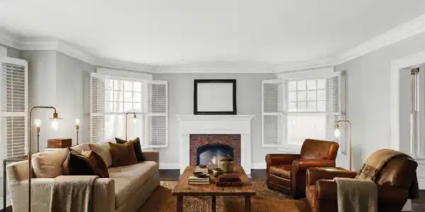 Image 2: The front living room centers on a gas fireplace flanked by shuttered windows, a warm and inviting setting for evenings in. (Photo is virtually staged)