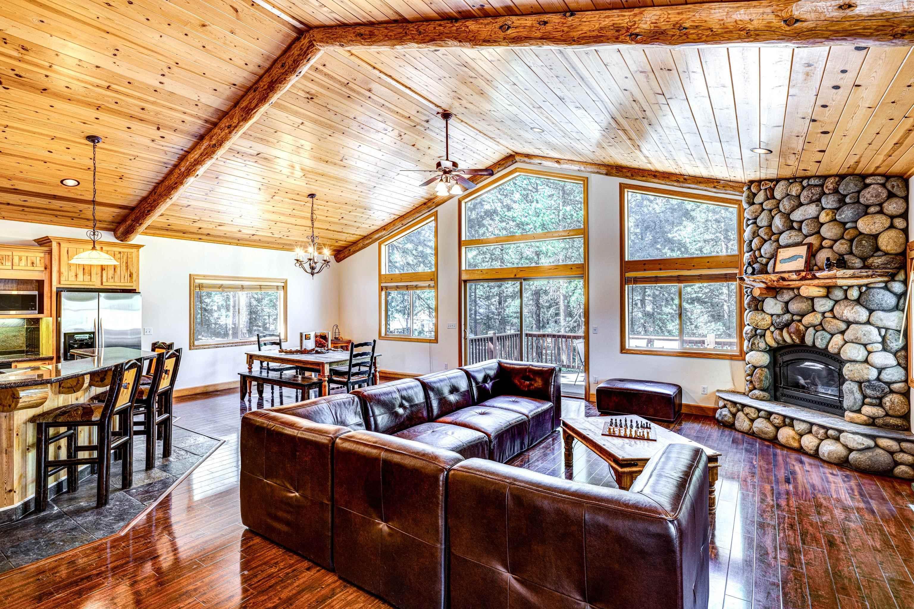 Image 2: Open floor plan with high vaulted ceilings and log beams., Great Room