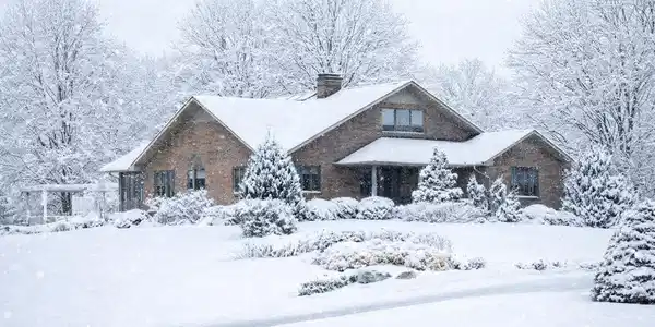 Image 4: Snowy winter home with brick details