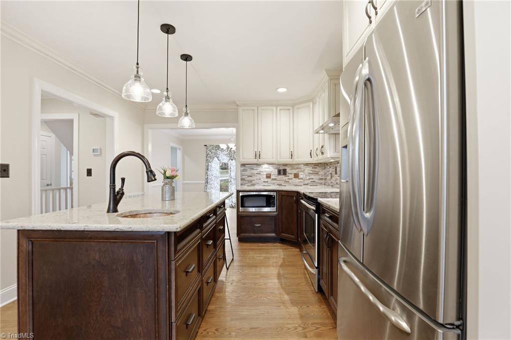 Image 4: The copper prep sink in the kitchen island is both stylish and extremely useful. Under counter lighting and tile backsplash add that extra touch of detail and convenience.