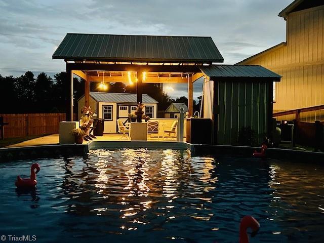 Image 2: Twilight photo of pool and pavillion provided by seller