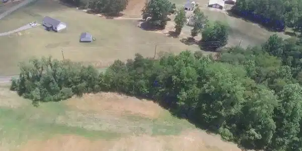 Image 3: Aerial view of wooded lot