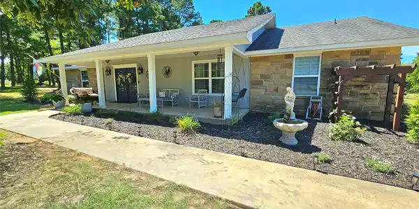 Image 2: Stone facade home featuring a covered front porch,