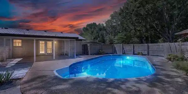 Image 3: Concrete patio with an inground swimming pool, fea