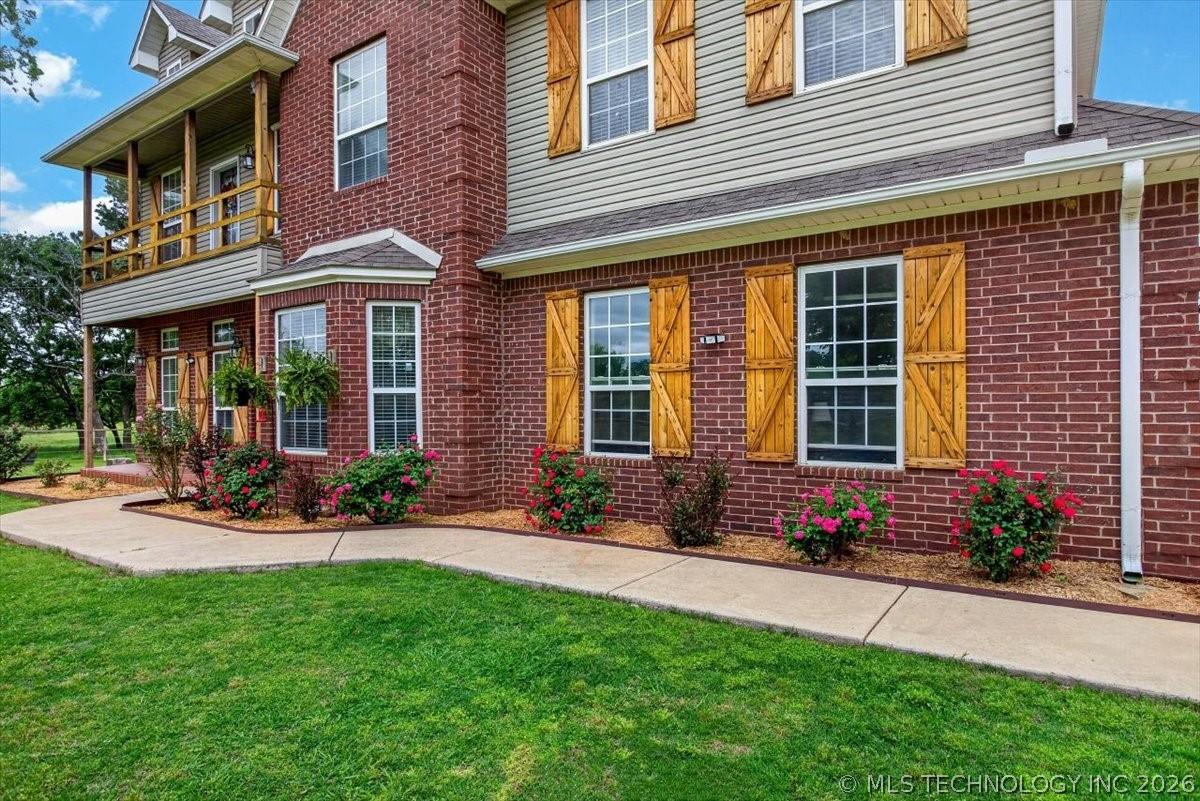 Image 2: Brick and siding exterior with natural wood shutte