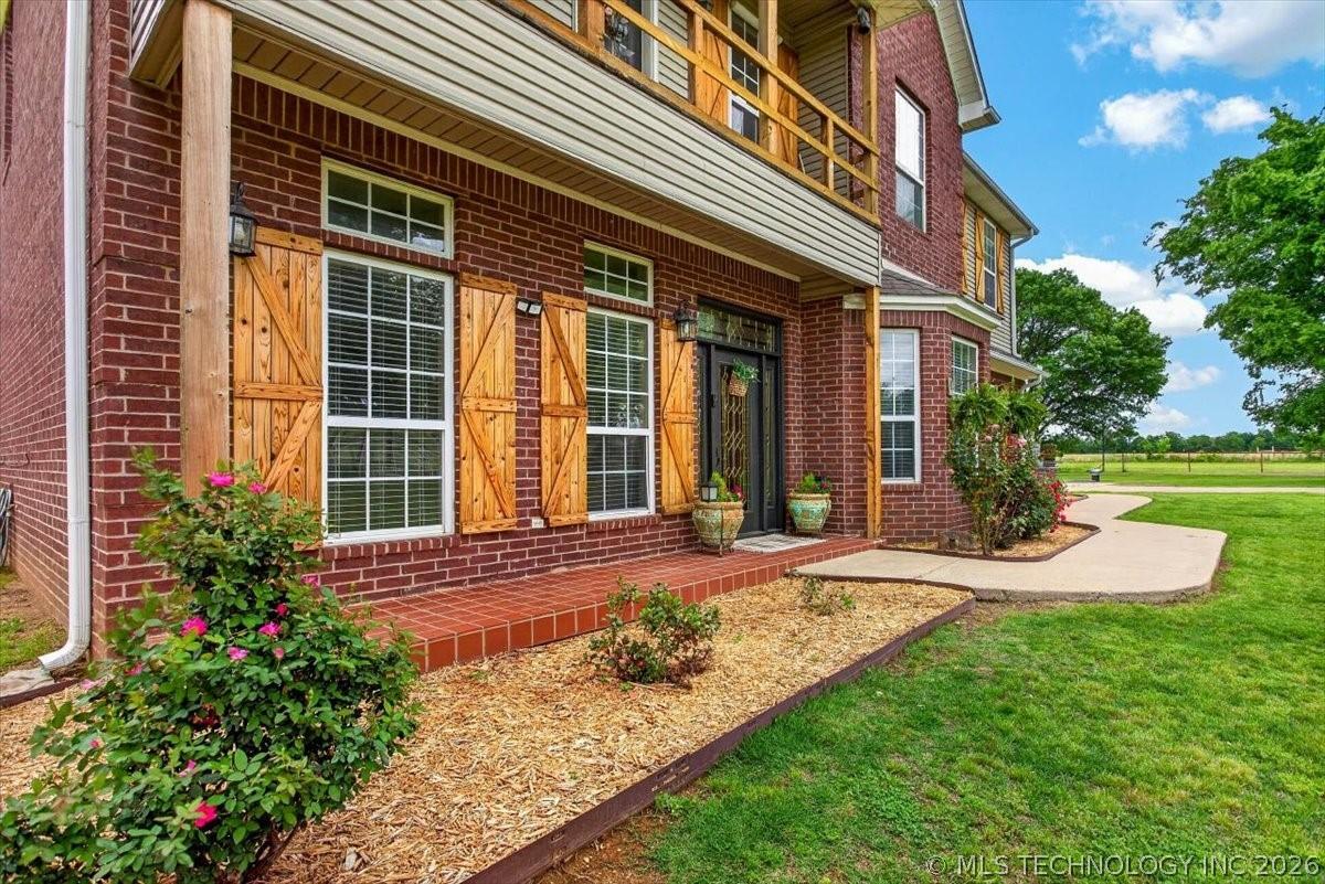 Image 3: Brick exterior featuring a covered porch with a wo
