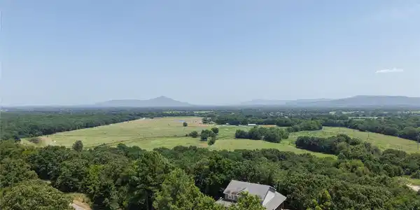 Image 2: Property featuring extensive tree coverage and a p