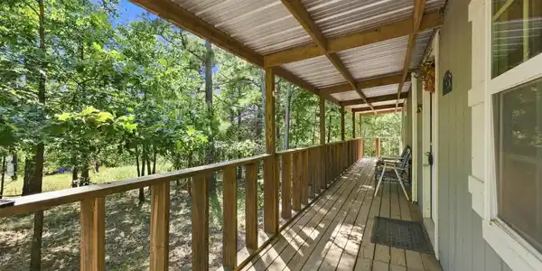 Image 3: Expansive covered wooden deck featuring a metal ro