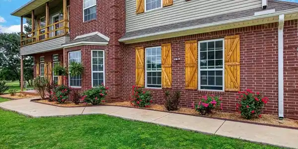 Image 2: Brick and siding exterior with natural wood shutte