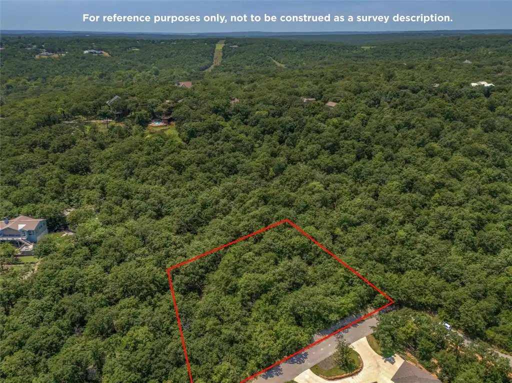 Image 1: Wooded lot bordered by mature trees and a paved st