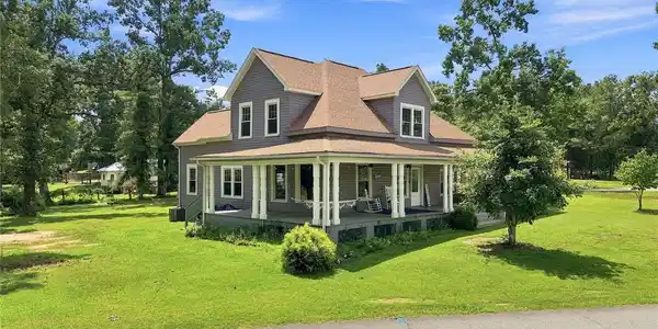 Image 2: An expansive wrap-around porch frames the front of