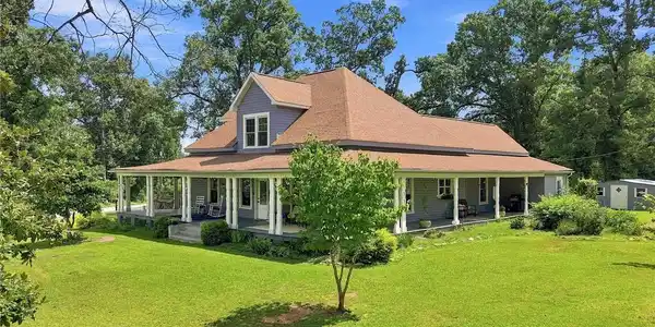Image 3: An expansive wrap-around porch frames this multi-l