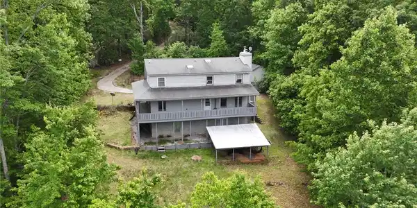 Image 2: Perched among lush greenery, this home offers tran