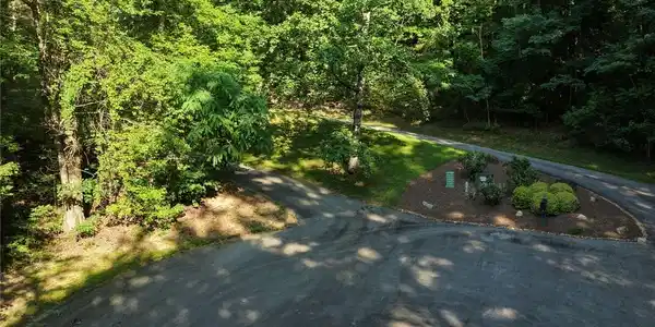 Image 3: A verdant, tree-lined landscape offers a paved roa