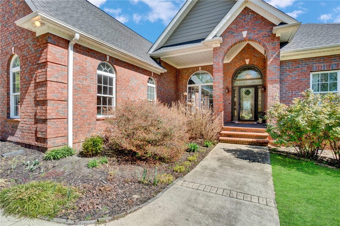 Image 3: This classic brick residence features an inviting