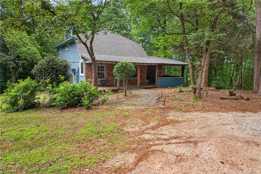 Image 1: A secluded retreat nestled in a wooded setting, of