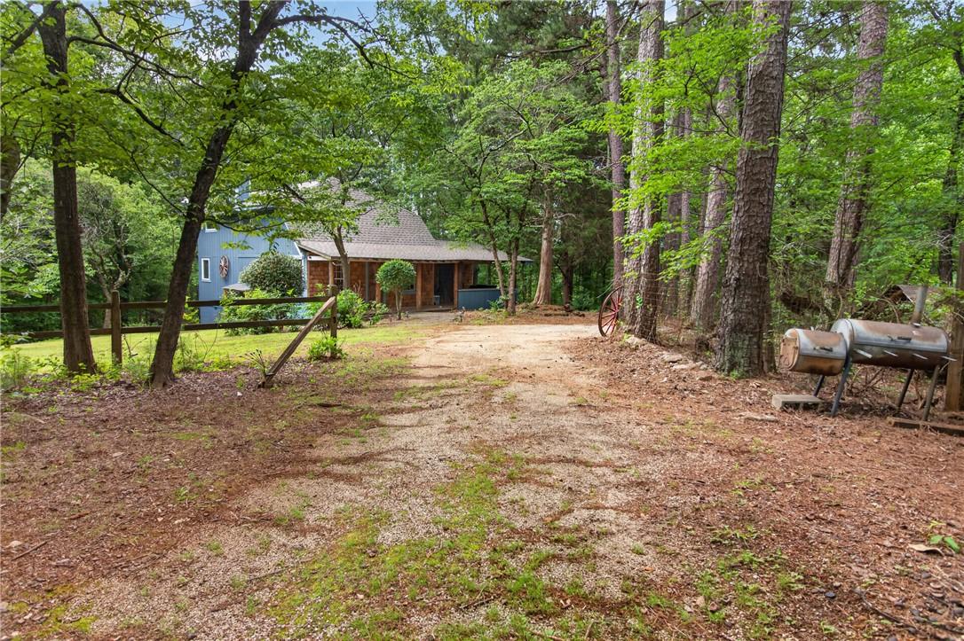 Image 3: A secluded wooded driveway leads to a charming rus