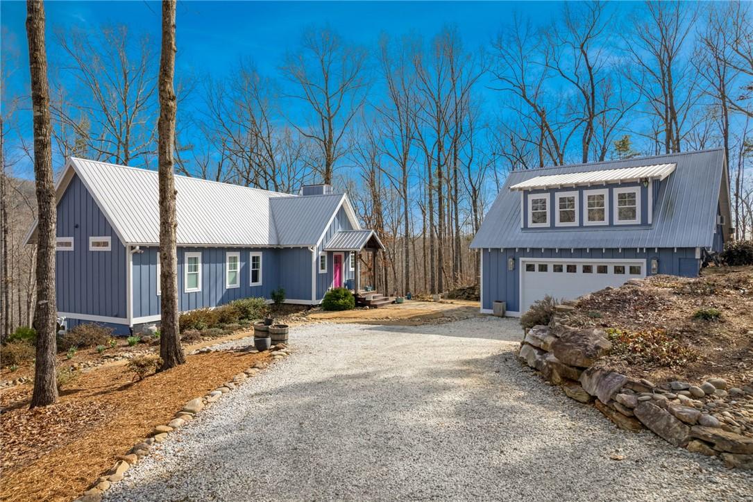 Image 1: This charming home features a detached garage, off