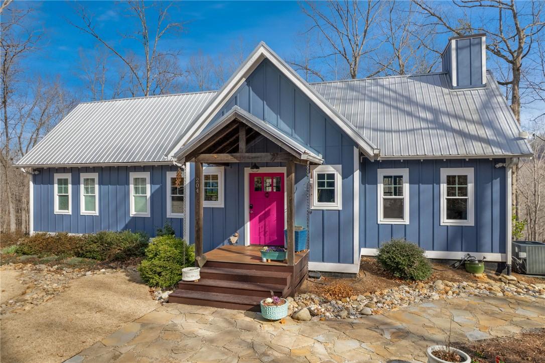Image 2: This charming home features a striking pink front