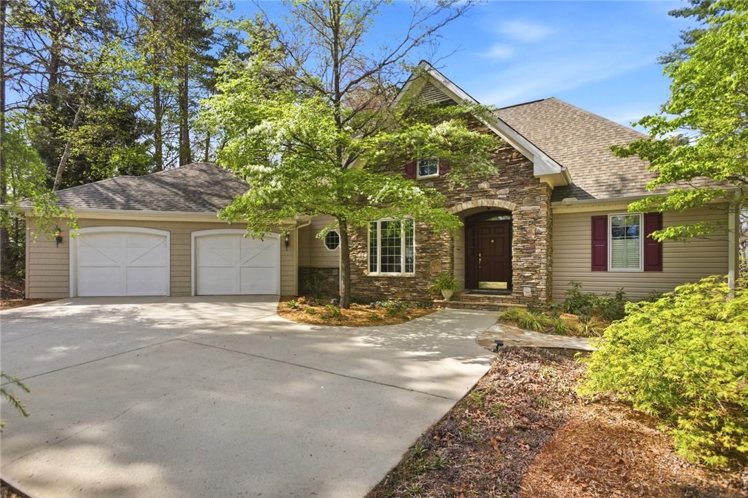 Image 1: This charming home features a lovely stone facade