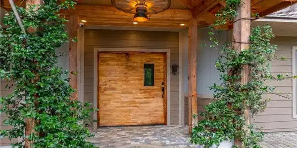 Image 3: A rustic entry welcomes with a wooden front door,