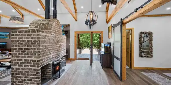 Image 4: A spacious entry showcases exposed wood beams, a s