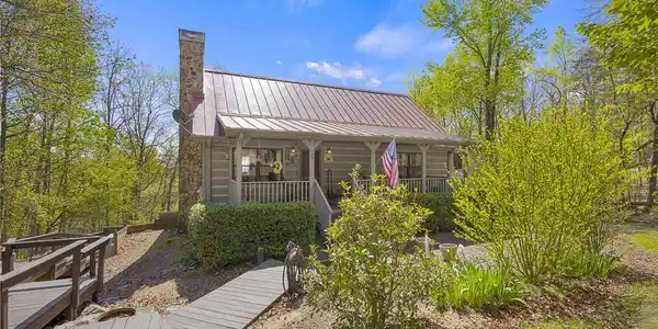 Image 4: This inviting home is nestled among trees, offerin