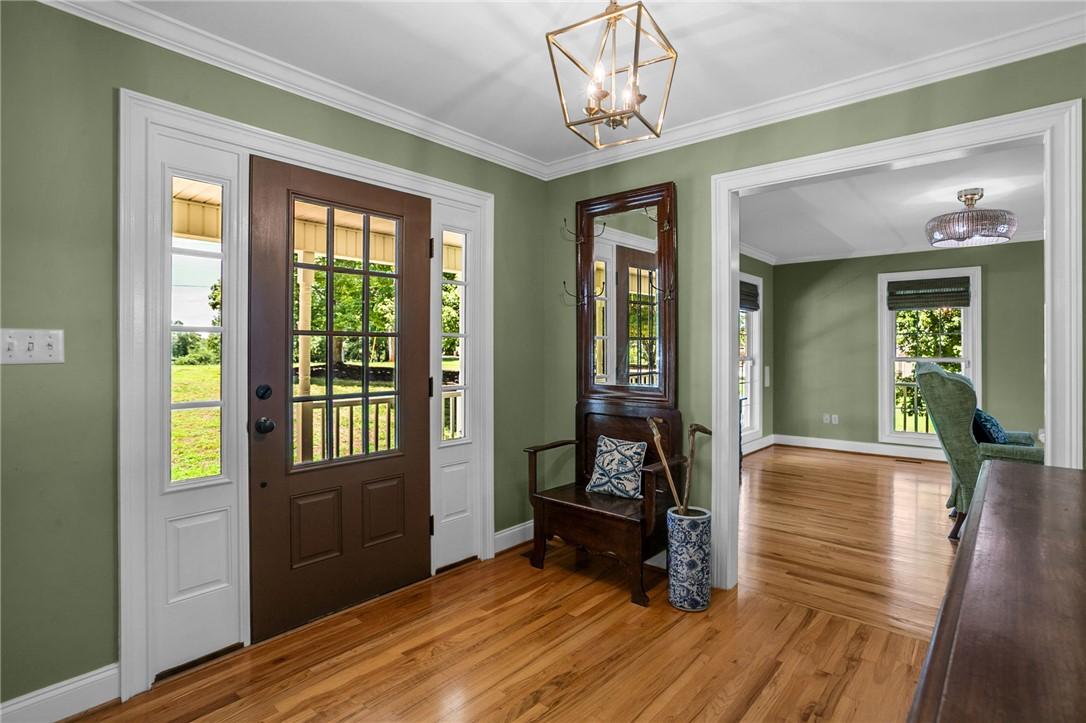 Image 2: A welcoming entry hall with hardwood flooring and