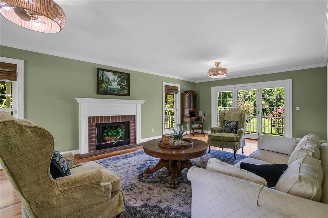 Image 3: An inviting living area featuring a brick fireplac