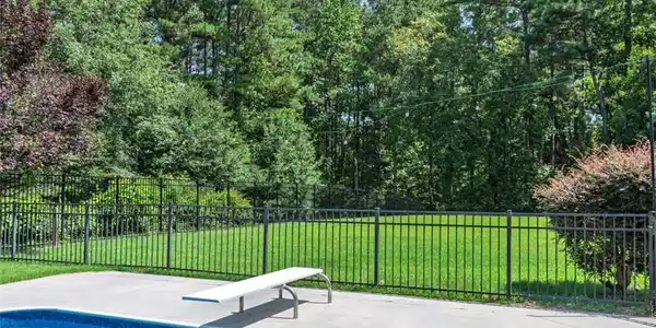 Image 3: A well-maintained pool and diving board complement