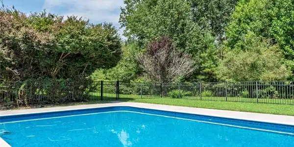 Image 4: An inviting backyard oasis offers a sparkling in-g