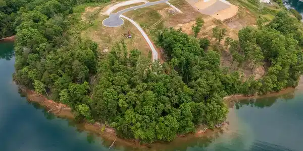 Image 3: Lush woodlands embrace a tranquil waterfront, reve