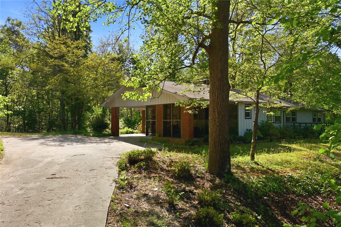 Image 4: This charming home sits amidst a lush, verdant lan