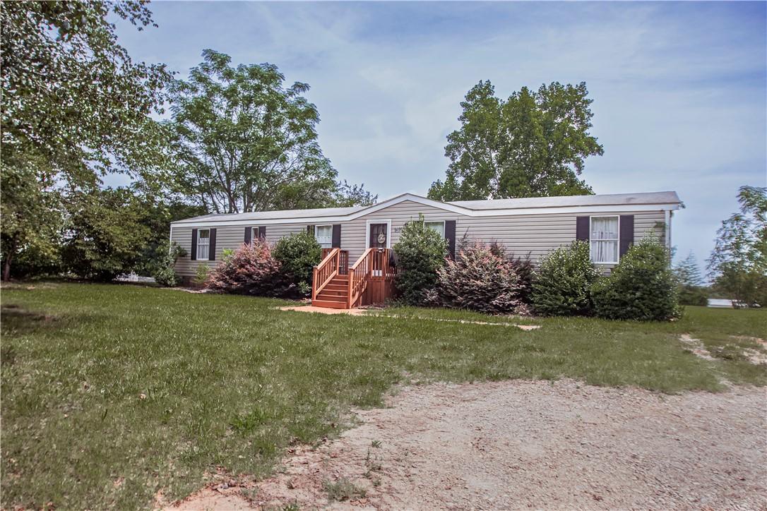 Image 2: A well-maintained manufactured home nestled amidst