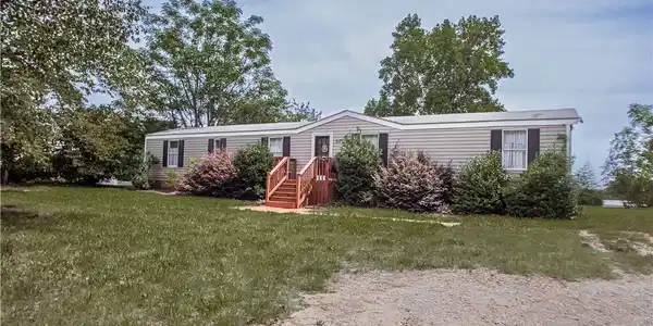 Image 2: A well-maintained manufactured home nestled amidst