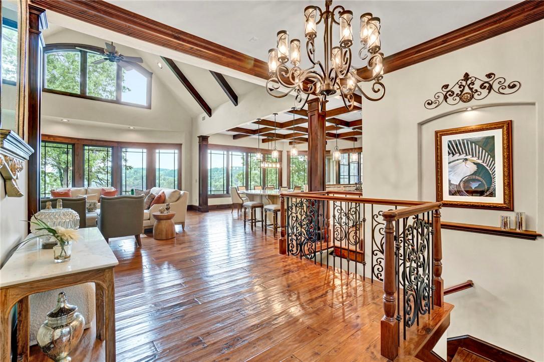 Image 3: Ornate wrought iron banisters lead to a grand livi