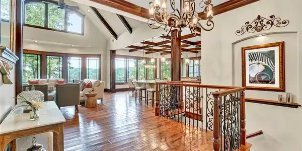 Image 3: Ornate wrought iron banisters lead to a grand livi