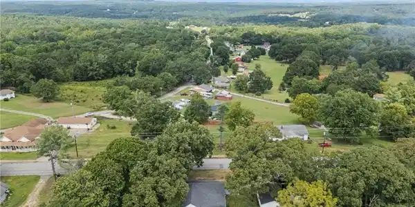 Image 2: Lush forest canopies frame a peaceful aerial panor