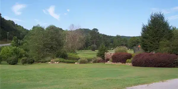 Image 2: Lush greens and mature trees define this picturesq