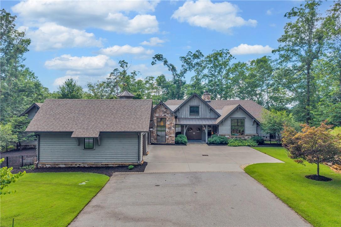 Image 1: A winding driveway leads to a modern farmhouse wit
