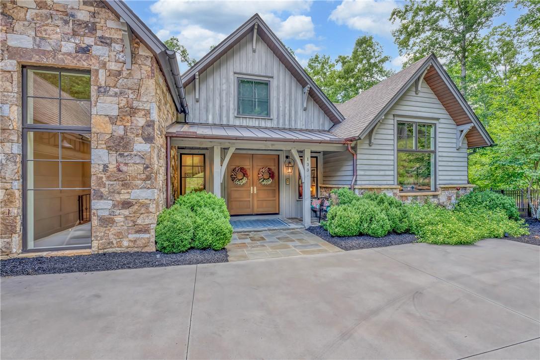 Image 3: Crafted with natural stone and wood siding, this i