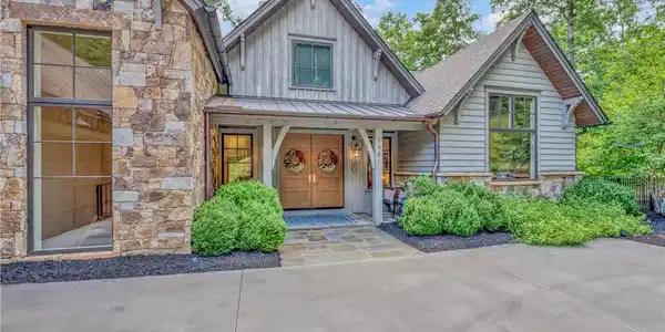 Image 3: Crafted with natural stone and wood siding, this i