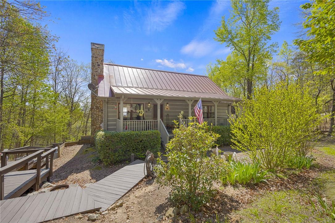 Image 4: This inviting home is nestled among trees, offerin
