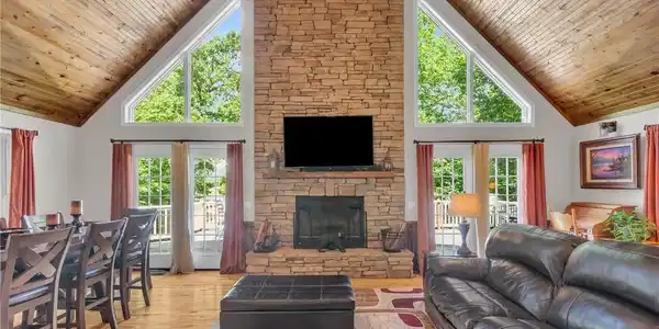 Image 3: A spacious living area features a grand stone fire
