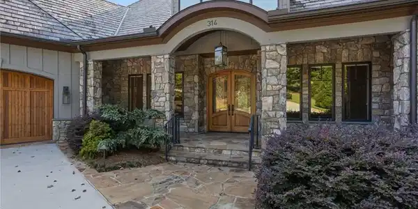 Image 2: A stone-clad facade with an arched entry and woode