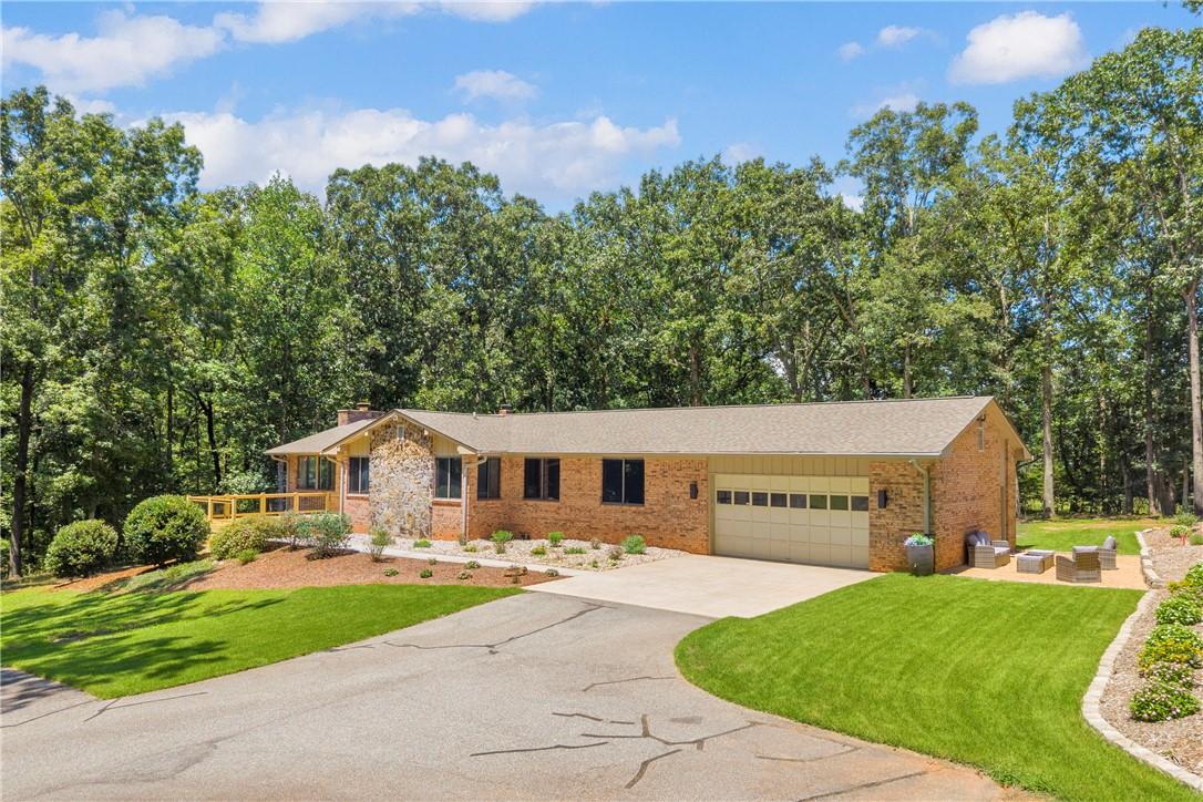 Image 2: A well-maintained brick and stone home with an att