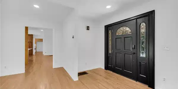 Image 4: A dark, ornate front door with decorative glass pa