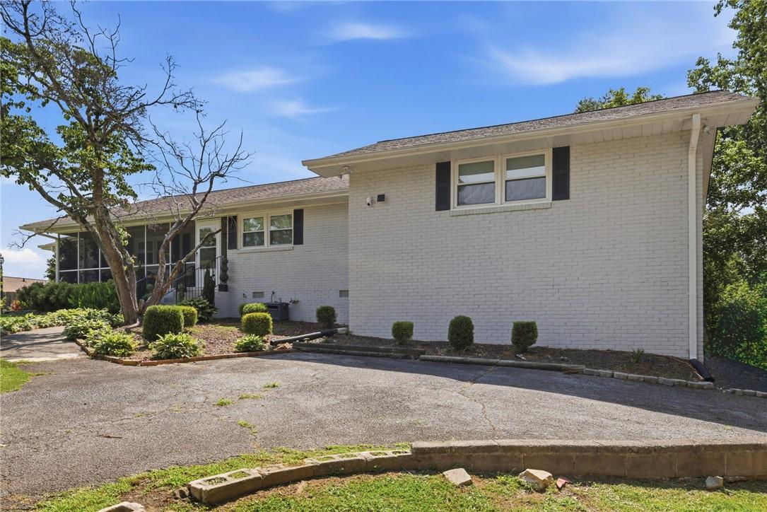 Image 2: A classic brick exterior, screened porch, and verd